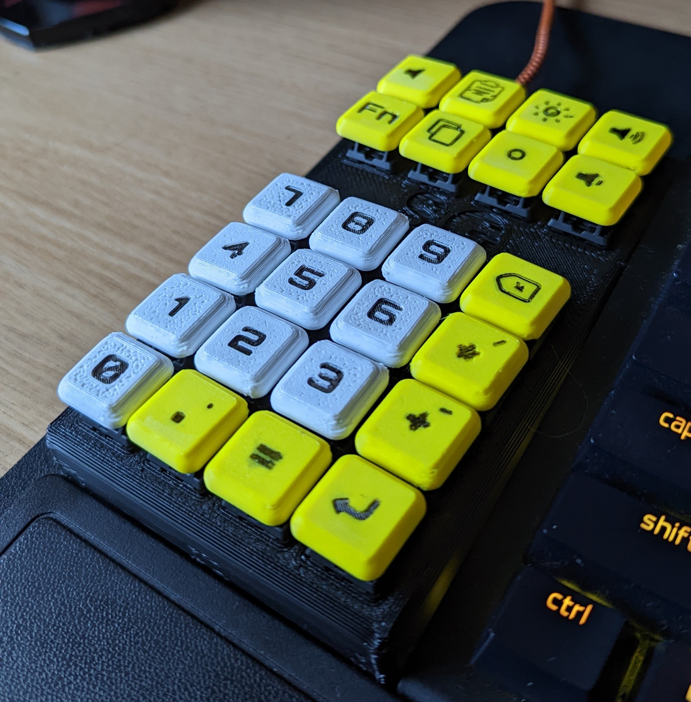 Picture of 3d-printed keypad with 24 keys. The number keys are white, the others are yellow. All have the legends painted in.